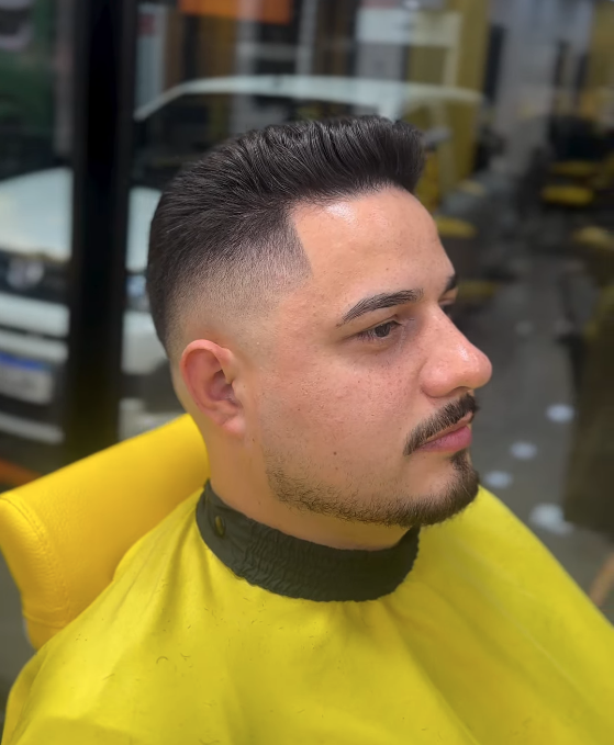 Cliente com corte degradê alto e acabamento na navalha